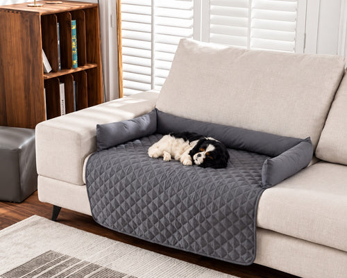 Ash Everyday Sofa Mat on a cream sofa with a small dog lying on it